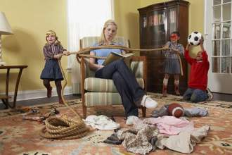 three young children tying a mother up with rope in living room causing chaos