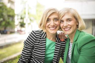 twin women with the same haircut wearing similar clothing