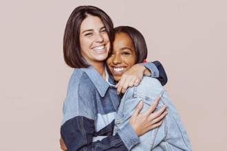 two friends hugging and smiling