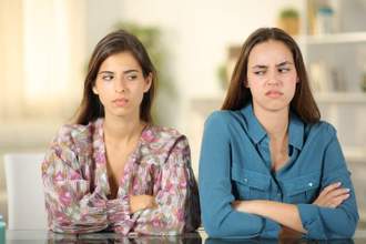 two friends standing next to each other with their arms crossed while side eyeing angrily