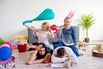 two little girls sitting on top of their distraught parents causing chaos in the room