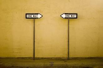 two one way signs pointing in opposite directions