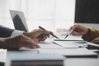 two people looking over a single document