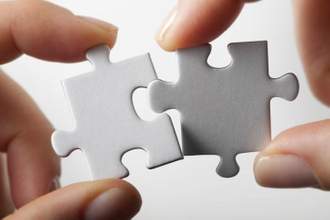 two people putting together pieces from a puzzle