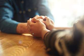 two people with hands joined