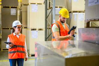 two warehouse workers diligently checking their inventory