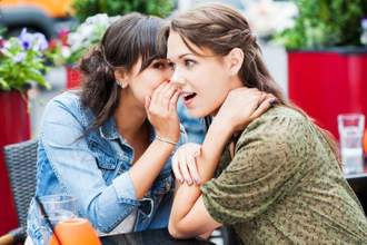 two women gossiping about someone nearby which they sit at lunch