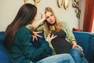 two women having a heated conversation with one looking annoyed