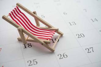 unfolded toy beach chair on sitting on blank calendar