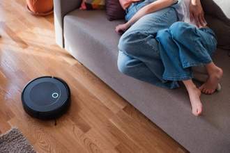 vacuum robot cleaning while couple are laying on the couch