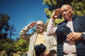 war veteran and men at cemetery to pay respect to fallen soldier
