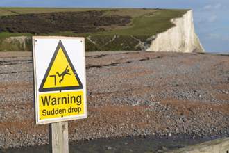 warning sudden drop sign next to cliff
