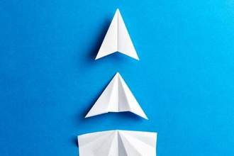 white paper airplanes under construction on blue background