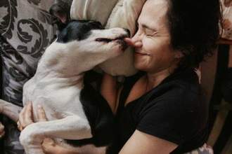 woman being licked by her dog