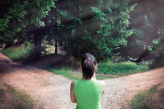 woman contemplating which direction to take at a forked road