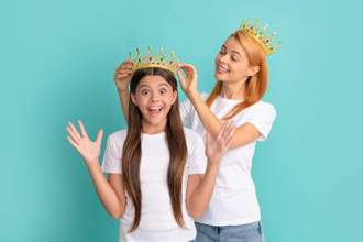 woman crowning her excited daughter