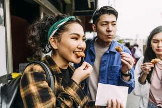 woman eating street food with friends