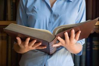 woman holding a large heavy book