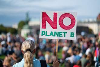 woman holding a sign that says no planet b at a protest