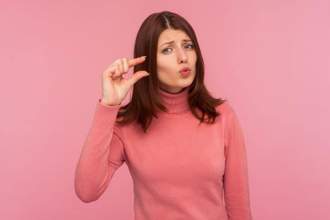 woman holding her fingers up to show a small amount