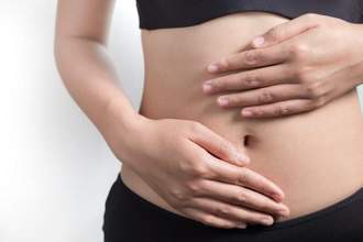 woman holding her hands above her midriff