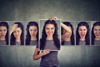 woman holding up several pictures in front of her face with all her emotions