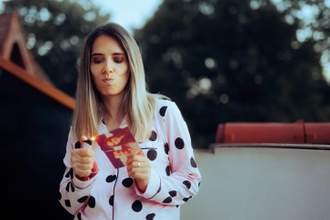 woman lighting a picture of her and her ex-boyfriend on fire