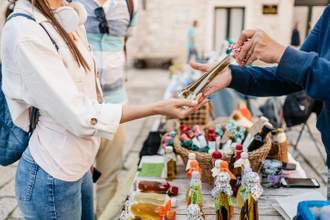 woman looking at homemade liquors sold by a local street vendor