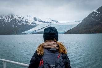 woman looking at mountain range and glacier