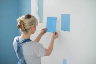 woman looking at two very similar blue paints