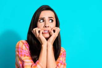 woman looking concerned while pretending to bite her fingernails