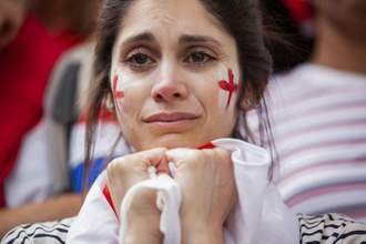 woman looking distraught and sad while watching the england football team