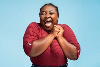 woman looking excited clutching her hands to her chest