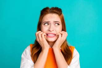 woman looking scared and biting her nails