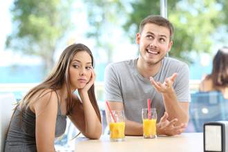 woman looking uninterested in mans conversation