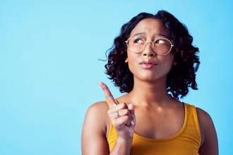 woman looking up pointing her finger up at the air thinking
