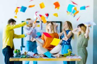 woman meditating while her coworker create chaos behind her