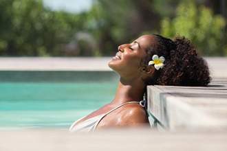 woman peacefully resting while in the pool