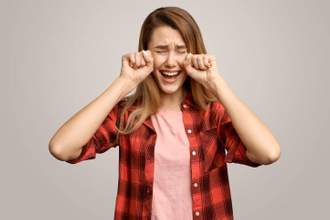 woman placing her hands on the side of her head pretending to cry