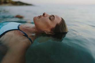 woman relaxing and floating in the calm waters