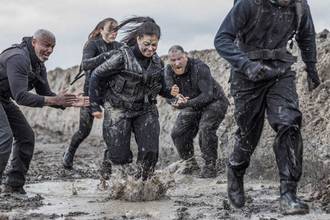 woman running through the mud during boot camp