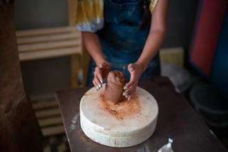 woman shaping clay on a palette