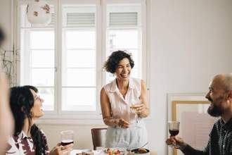 woman smiling at her guests while hosting a party