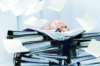 woman stuck behind stack of binders and paperwork