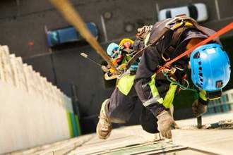 worker hangs over residential facade building during high rise cleaning work