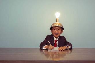 young boy in a business suit wearing a lit up thinking cap
