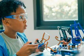 young boy working excitedly on his robotics project