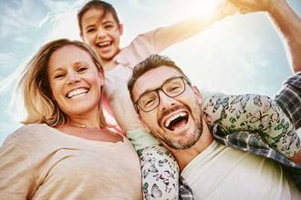 young couple cheerfully hold their daughter