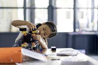 young girl working on a robot