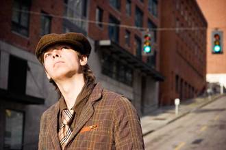 young man wearing fancy old clothing looking off to the side